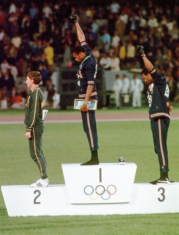 Why Tommie Smith and John Carlos received their medals wearing black socks and no shoes?